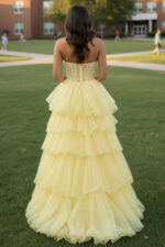 Vestido amarillo de tul con volantes y corpiño escarpado deshuesado